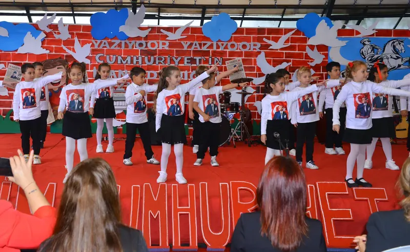 Ellerinde Türk bayraklarıyla tören gösterisi yapan ilkokul öğrencileri