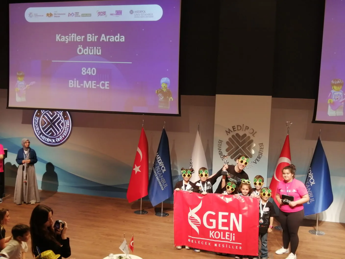 FIRST LEGO League turnuvasında sahnede GEN Koleji pankartıyla ödül alan öğrencilerimiz